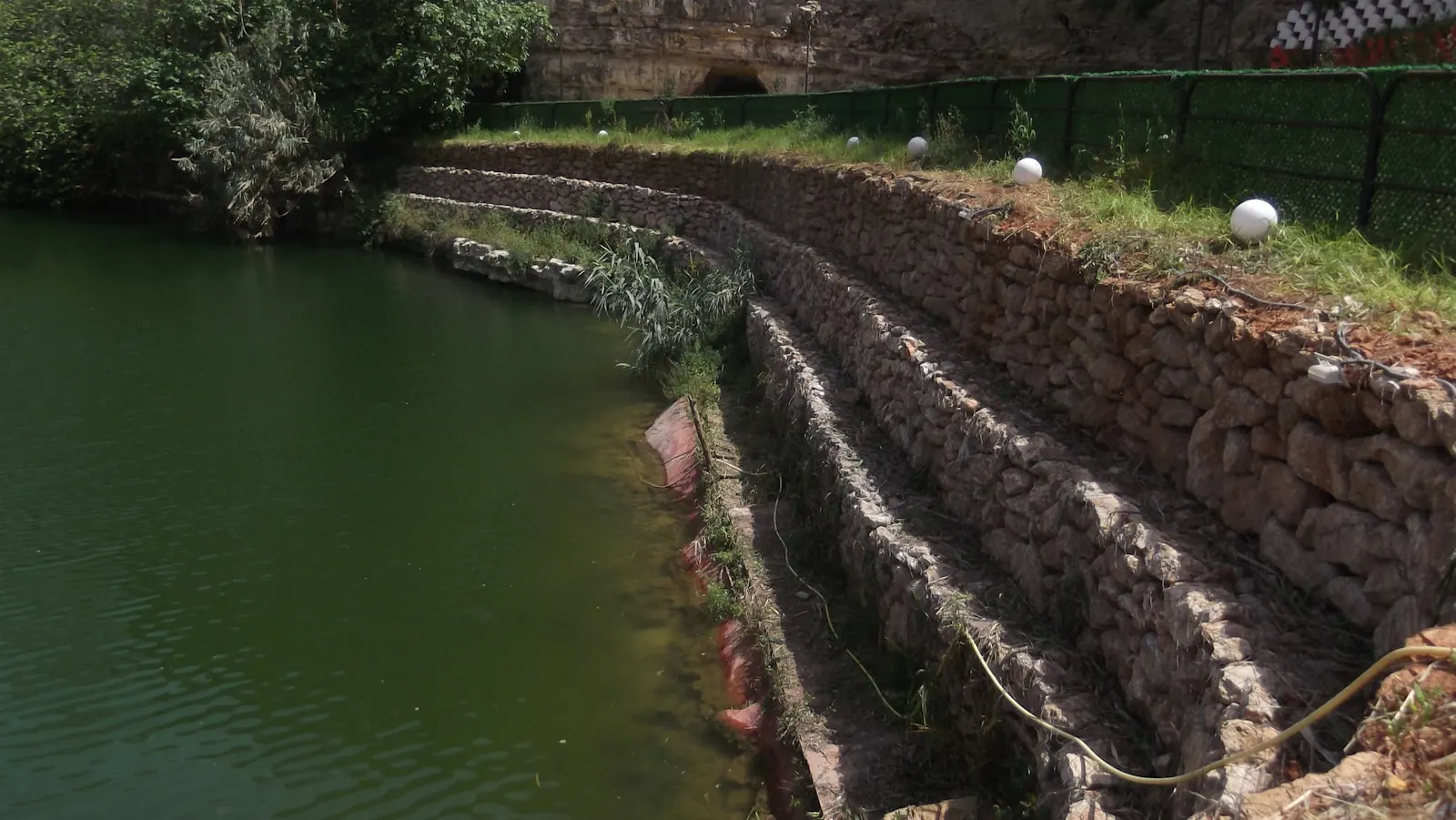 Terraced stone retaining wall holding back a grassy bank